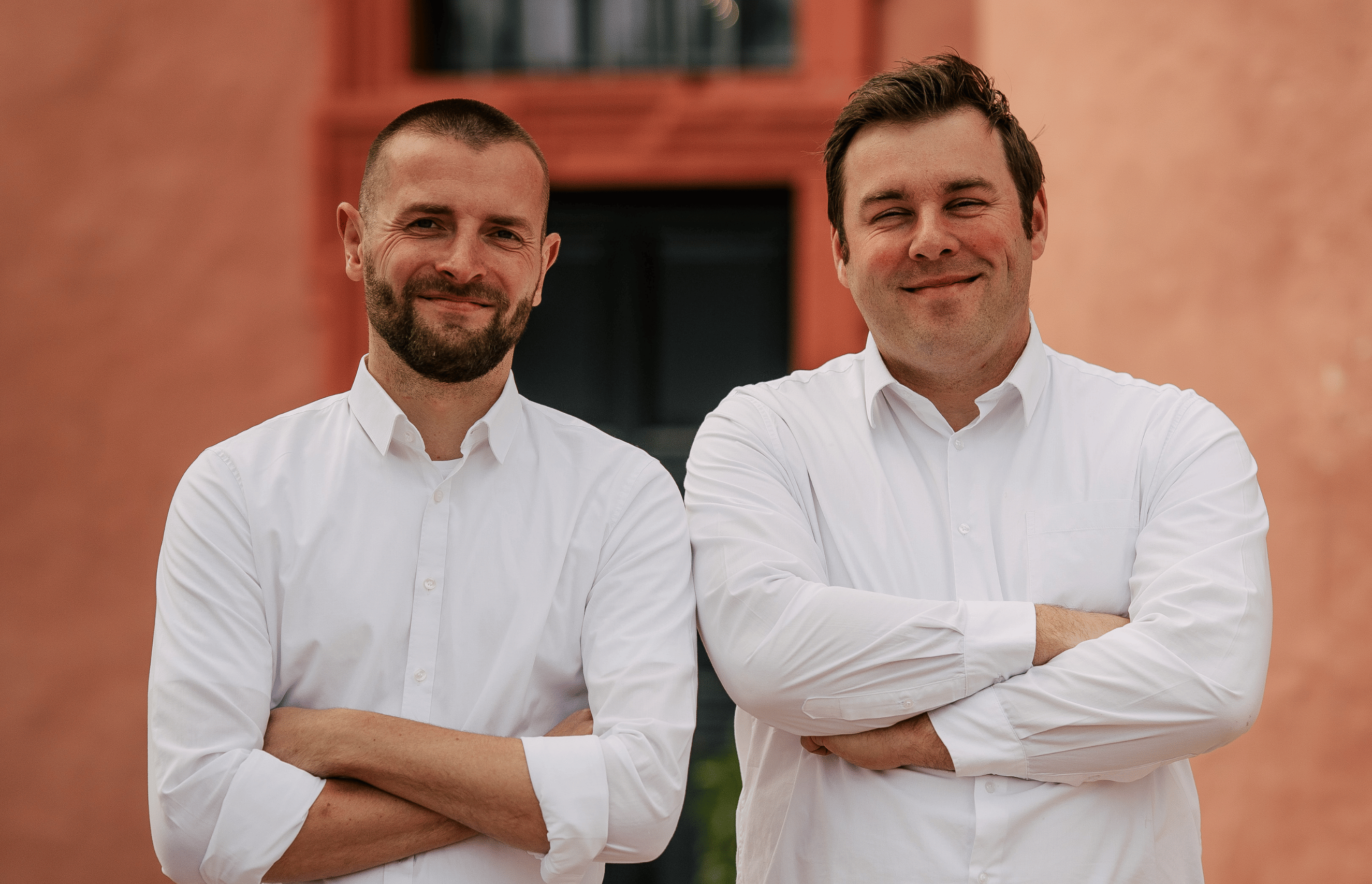 Zu sehn sind unsere Sommeliers Niklas und Florian die nebeneinander stehen und freundlich in die Kamera lächeln